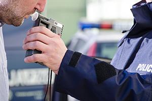 a man blowing an alcolimeter